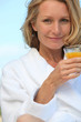 Woman in robe with glass of juice