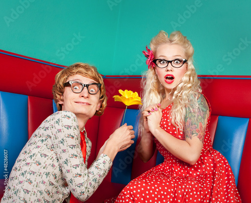 Photo: Surprised young woman getting flower from a nerdy guy Surprised young woman getting flower from a nerdy guy