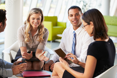 Photo: Businesspeople With Digital Tablet Having Meeting In Office Businesspeople With Digital Tablet Having Meeting In Office