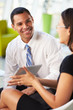 Businesspeople With Digital Tablet Having Meeting In Office