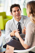 Businesspeople With Digital Tablet Having Meeting In Office