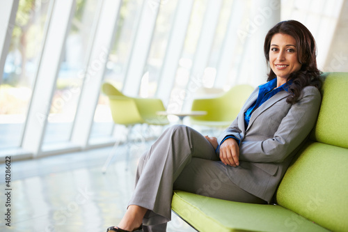 Photo: Portrait Of Businesswoman Sitting On Sofa In Modern Office Portrait Of Businesswoman Sitting On Sofa In Modern Office