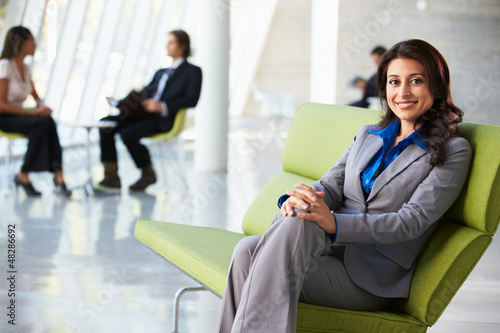 Photo: Portrait Of Businesswoman Sitting On Sofa In Modern Office Portrait Of Businesswoman Sitting On Sofa In Modern Office