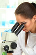 Young scientist looking into  microscope in  laboratory.
