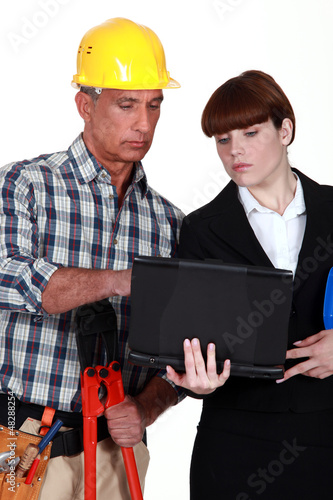 Photo: Builder and architect using laptop together Builder and architect using laptop together