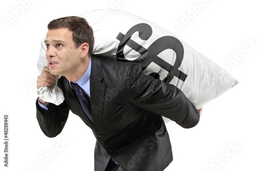 Photo: A businessman carrying a money bag with US dollar sign A businessman carrying a money bag with US dollar sign