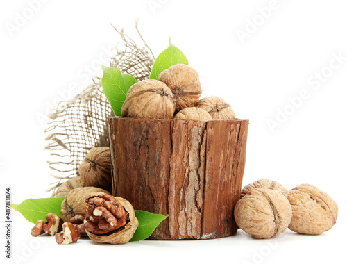 Photo: walnuts with green leaves in woooden vase, isolated on white walnuts with green leaves in woooden vase, isolated on white