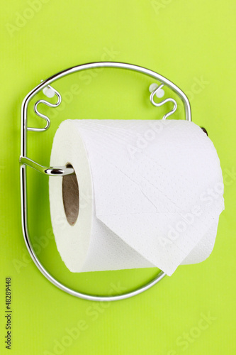 Photo: Roll of toilet paper on holder fixed to wall Roll of toilet paper on holder fixed to wall