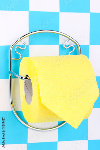 Photo: Roll of toilet paper on holder fixed to wall Roll of toilet paper on holder fixed to wall