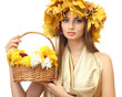 beautiful young woman with yellow autumn wreath and basket with