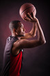 Portrait of a young male basketball player against black backgr