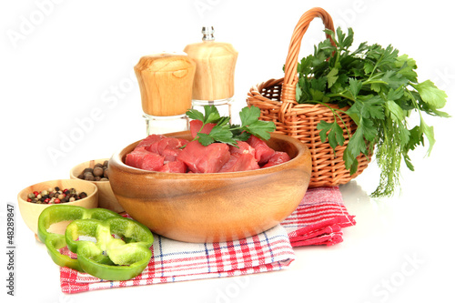 Photo: Raw beef meat in bowl with herbs and spices isolated on white Raw beef meat in bowl with herbs and spices isolated on white