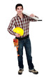 Young builder carrying a plank of wood