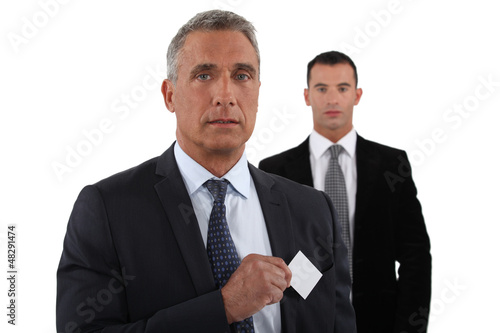 Photo: Company CEO removing business card from pocket Company CEO removing business card from pocket