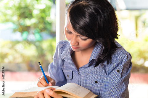Photo: Girl with pile of books learning Girl with pile of books learning