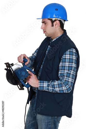 Photo: Man holding circular saw Man holding circular saw