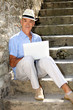 senior ma n relaxing outdoors with his laptop