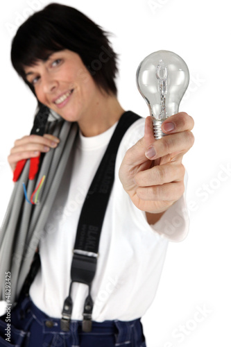 Photo: Female electrician showing light bulb Female electrician showing light bulb