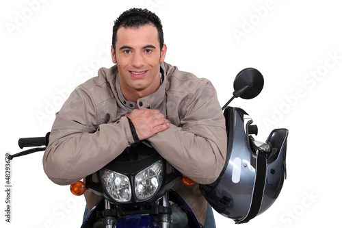 Photo: Man on a motorbike with his helmet on the side Man on a motorbike with his helmet on the side