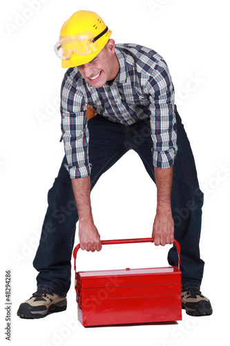 Photo: laborer lifting heavy toolbox laborer lifting heavy toolbox