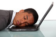 Young businessman asleep on laptop