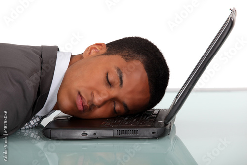 Photo: Young businessman asleep on laptop Young businessman asleep on laptop