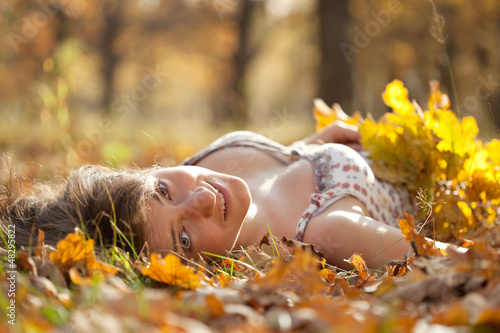 Photo: Young woman lies in autumn park Young woman lies in autumn park
