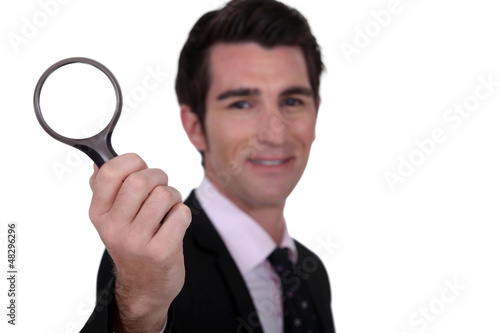 Photo: detective holding magnifying glass isolated on whiet detective holding magnifying glass isolated on whiet