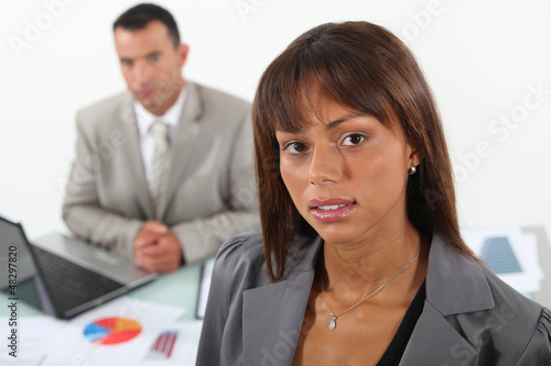 Photo: Two business people working on statistical data Two business people working on statistical data