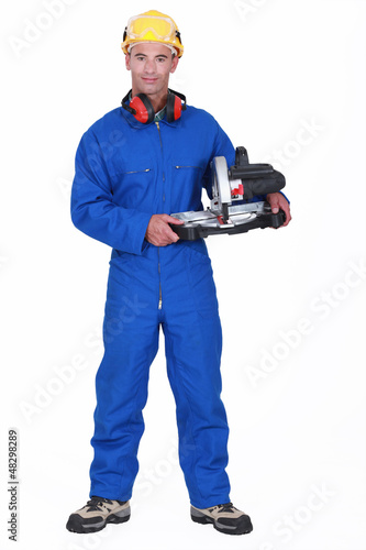 Photo: Handyman holding a circular saw Handyman holding a circular saw
