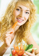 Foto: Young woman eating vegetables Young woman eating vegetables