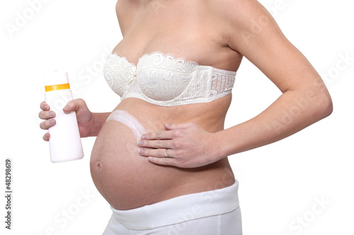 Photo: Pregnant woman putting cream on her belly Pregnant woman putting cream on her belly