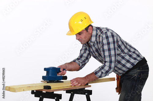 Photo: Workman using a power tool Workman using a power tool