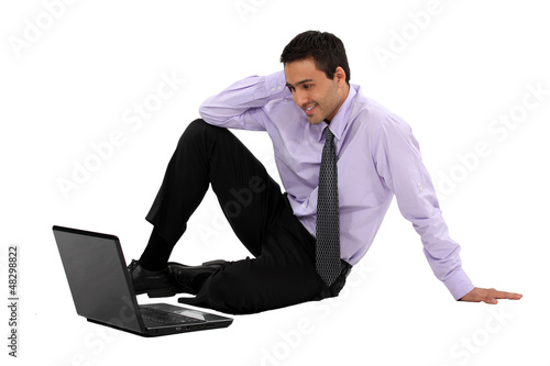 Photo: Businessman watching a movie on his laptop Businessman watching a movie on his laptop