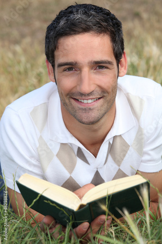 Photo: Man reading on the grass Man reading on the grass