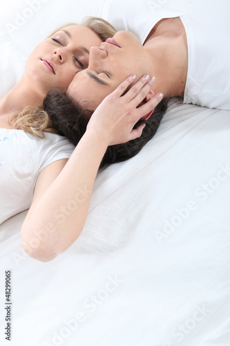 Photo: Affectionate young couple laying in bed Affectionate young couple laying in bed