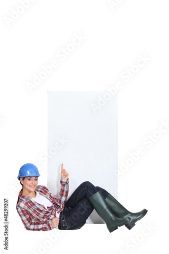 Photo: Construction worker pointing at poster. Construction worker pointing at poster.