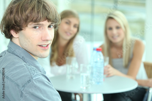 Photo: Teenager sitting with his female friends Teenager sitting with his female friends