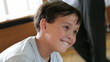 Boy is grimacing in front of the distorting mirror.