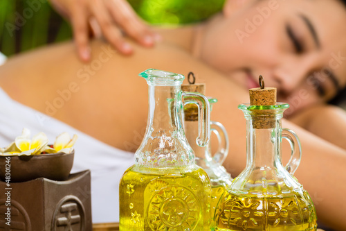 Photo: Asian woman having a massage in tropical setting Asian woman having a massage in tropical setting