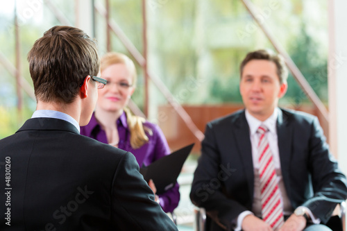 Photo: Man having an interview with manager and partner employment job Man having an interview with manager and partner employment job