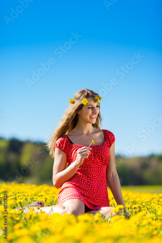 Photo: Girl in spring on a flower meadow with dandelion Girl in spring on a flower meadow with dandelion