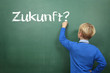 Kind vor der Tafel mit dem Thema Zukunft