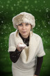 young woman blowing snow on green background with stars