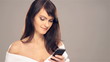 Young brunette girl typing a text message on her mobile phone