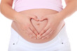 Schwangere Frau formt Herz auf ihrem Bauch