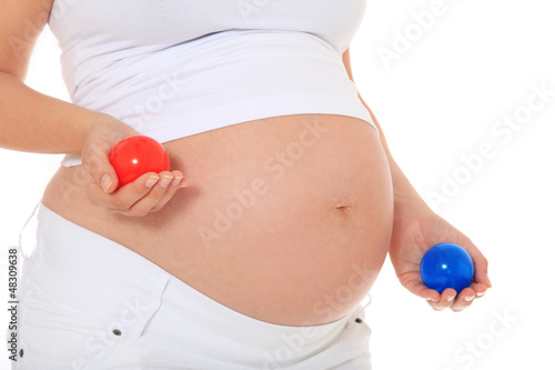 Photo: Schwangere Frau hält blauen und roten Ball Schwangere Frau hält blauen und roten Ball