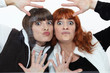 Two women pressing their faces against glass