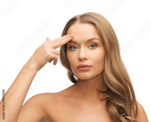 Photo: beautiful woman pointing to forehead beautiful woman pointing to forehead