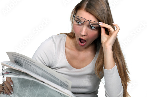 Photo: Woman shocked reading newspaper Woman shocked reading newspaper
